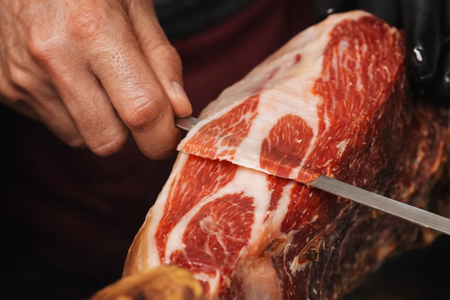 Pieza de jamón ibérico lista para el corte sobre un jamonero
